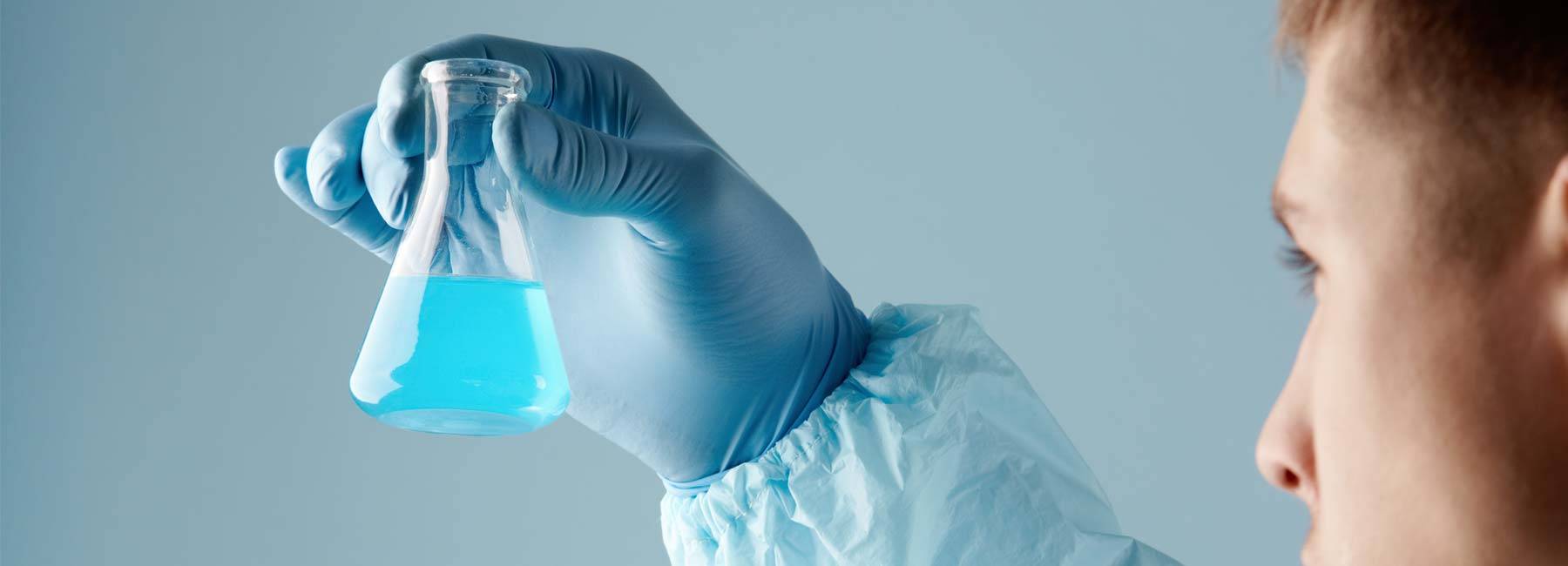 a picture of a scientist holding up a chemical jar with chemical in it