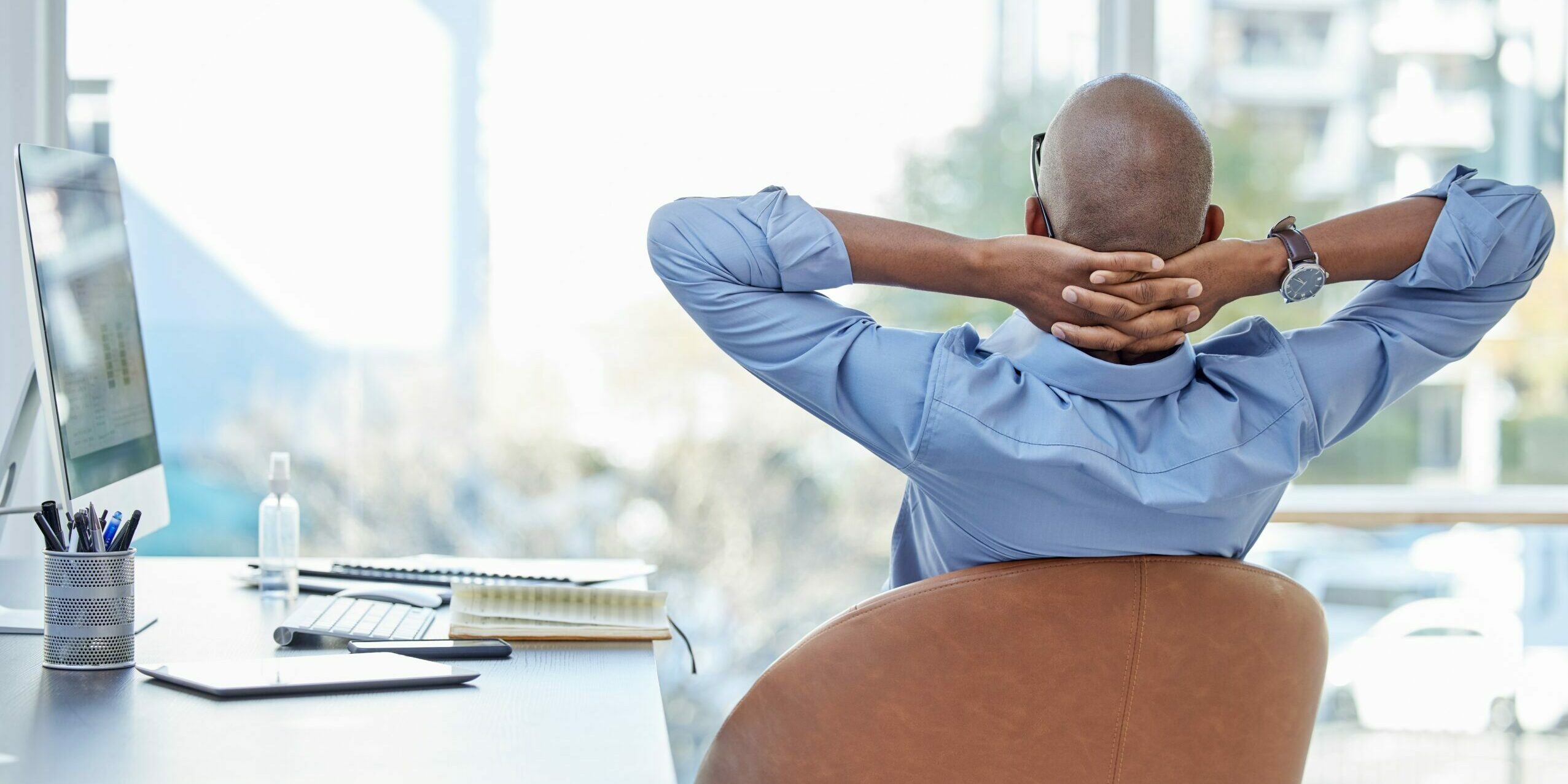 man sitting back in chair in office looking relieved as he is not affected by 3M existing manufacturing of cleaning solvents